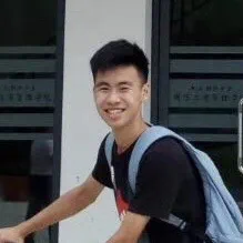 Yuan smiling with a backpack in front of a college building