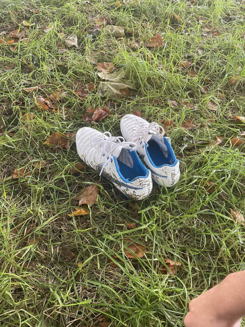 A pair of white football boots on the grass