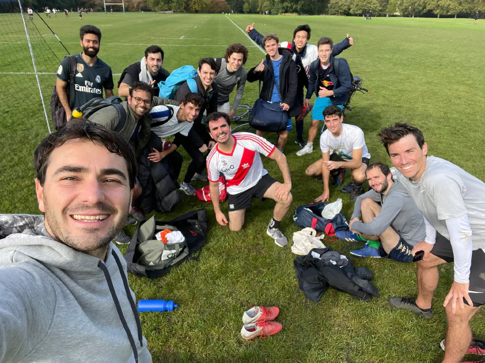 Selfie of smiling teammates sitting on the pitch after a game