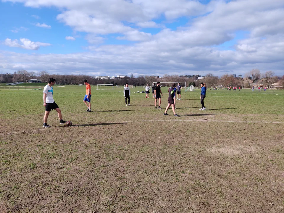 Friends playing a casual game on a park pitch in London