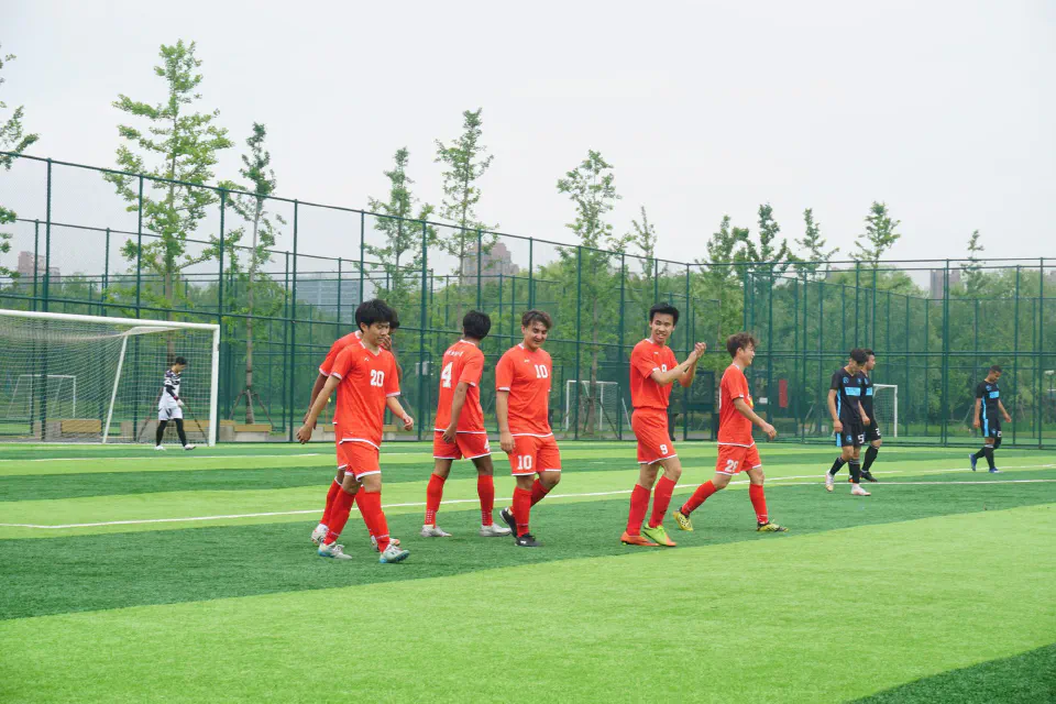 Players in orange walking back together after scoring